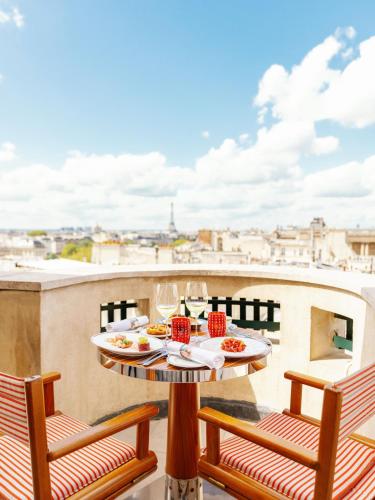 a table with plates of food on top of a balcony at Cheval Blanc Paris & Dior Spa Cheval Blanc Paris in Paris