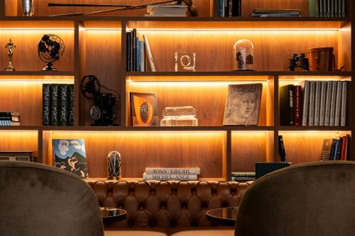 a room with a couch and shelves with books at Mercure Bayeux Omaha Beach in Port-en-Bessin-Huppain
