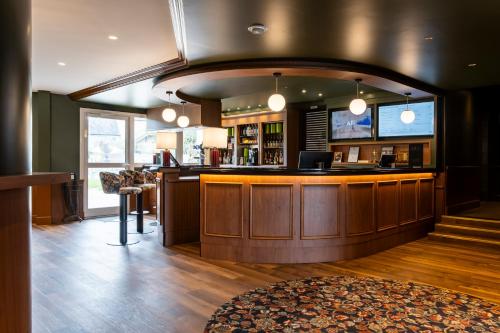 a lobby with a bar in a building at Mercure Bayeux Omaha Beach in Port-en-Bessin-Huppain