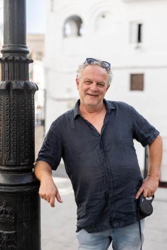 an older man standing next to a lamp post at Olive & Ivy Guesthouse in Canillas de Aceituno
