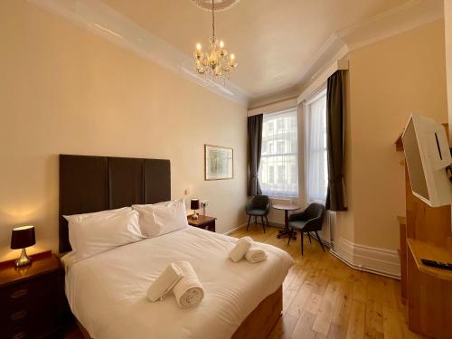 a bedroom with a bed with two towels on it at Vernon Guesthouse in Eastbourne