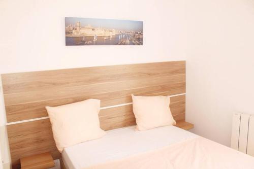 une chambre avec un lit avec une tête de lit en bois dans l'établissement Ideal Apartment For 4 By Marseille Airport, à Marignane