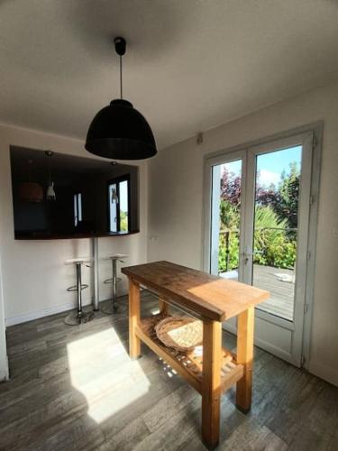 une salle à manger avec une table en bois et une fenêtre dans l'établissement Maison de vacances à Névez Des Lys d'Océan, à Névez