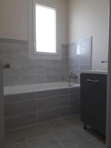 une salle de bain avec une baignoire et une fenêtre dans l'établissement Maison de vacances à Névez Des Lys d'Océan, à Névez