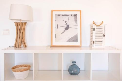 une étagère blanche avec un tableau et une lampe dessus dans l'établissement Cannes Elegance – Balcony & Quiet Near Shops, à Cannes