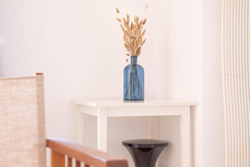 une table blanche avec un vase bleu sur elle dans l'établissement Cannes Elegance – Balcony & Quiet Near Shops, à Cannes