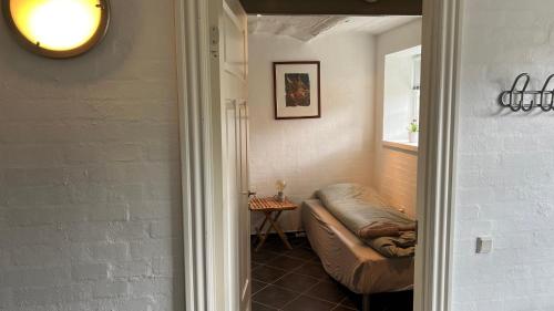 a hallway with a couch in a room with a window at Staudeengen et dejlig sted med fred og ro in Ålestrup