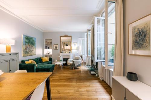 un salon avec un canapé vert et une table dans l'établissement GuestReady - Apt spacieux et exquis dans le 17ème, à Paris