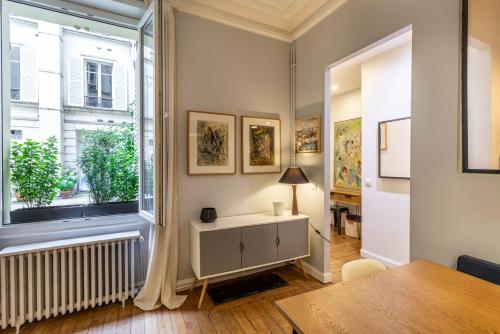 un salon avec une table et une fenêtre dans l'établissement GuestReady - Apt spacieux et exquis dans le 17ème, à Paris