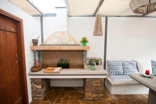 a patio with a brick fireplace in a room at Nephelis Heritage House in Moúdhros