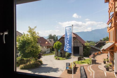 a view from a window of a town with a flag at Pension Kärnten in Seeboden