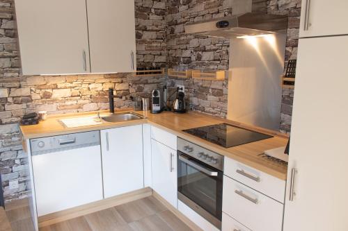 a white kitchen with a sink and a stove at Pension Kärnten in Seeboden