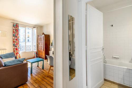 un salon avec un canapé et une salle de bains. dans l'établissement GuestReady - Apt Chaleureux dans le 5e arrondissement, à Paris