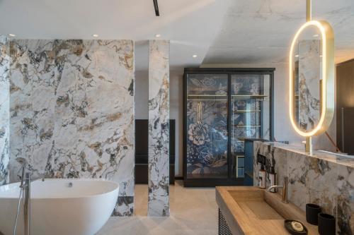 a bathroom with a white tub and a sink at Villa Urbana in Porticcio