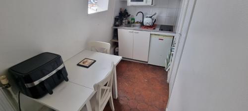 une petite cuisine avec une table blanche et un évier dans l'établissement Le Petit Paris, à Paris
