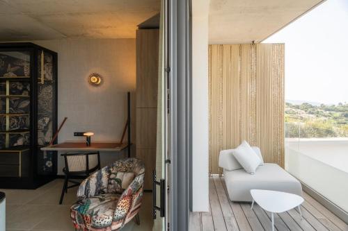 a living room with a white couch and a chair at Villa Urbana in Porticcio