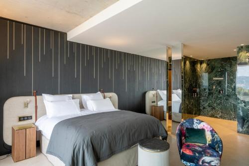 a bedroom with a large bed and a chair at Villa Urbana in Porticcio