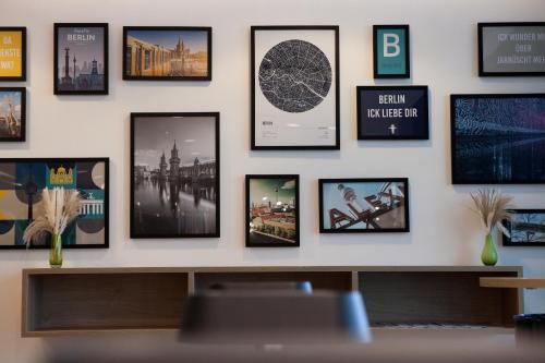 a wall with framed pictures on a wall at Holiday Inn Berlin City East Side by IHG in Berlin