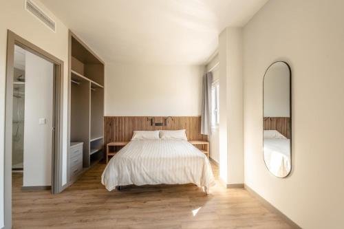 a bedroom with a bed and a large mirror at L'Alcor Aparthotel in Alicante