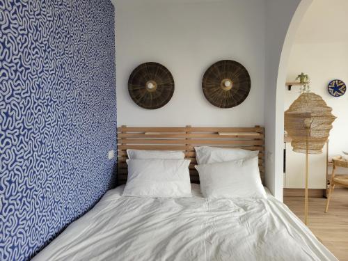 une chambre avec un lit avec un mur bleu et blanc dans l'établissement Appartement cocon Royan plage, à Royan