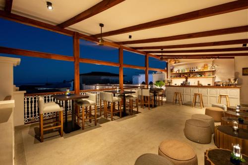 a restaurant with tables and chairs and a bar at The Neela Boutique Hotel Stone Town in Zanzibar City