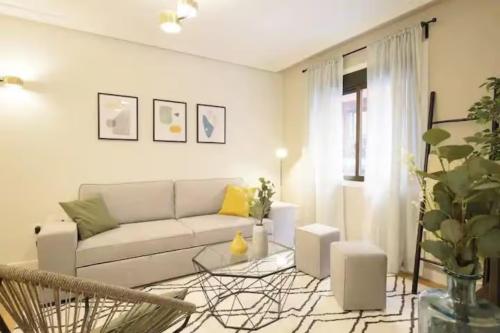 een woonkamer met een bank en een tafel bij GuestReady - Un Moderno Apartamento a un Paso de la Plaza Mayor in Madrid