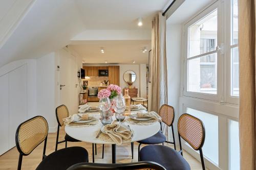 une salle à manger avec une table et des chaises blanches dans l'établissement Superb AC apartment Paris Center Bourse By Studio Prestige, à Paris