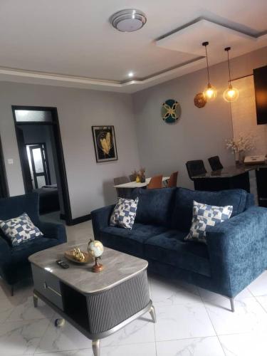 a living room with a blue couch and a table at MHP Apartments in Munyonyo