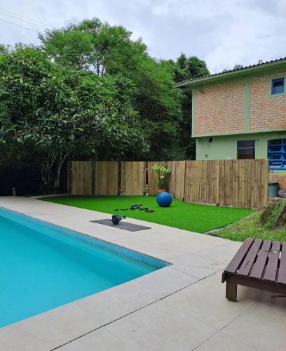 a backyard with a swimming pool and a wooden fence at Pousada Dona Francisca in Florianópolis