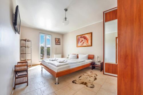 a bedroom with a bed and a chair and a mirror at Promenada I, Sun & Snow in Świnoujście