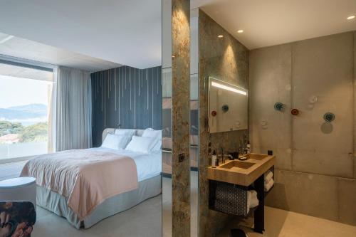 a bedroom with a bed and a bathroom with a shower at Villa Urbana in Porticcio