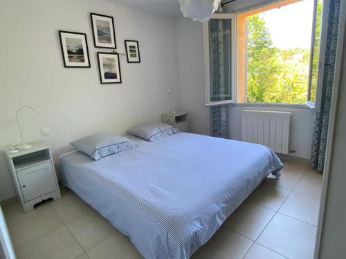 a white bedroom with a bed and a window at Villa spacieuse proche de Marseille avec jardin et piscine privée in La Tour-dʼAigues