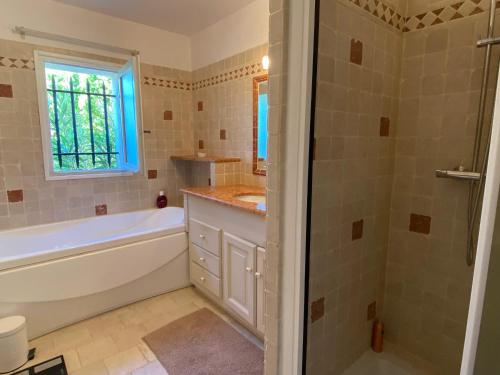 a bathroom with a tub and a sink and a shower at Villa spacieuse proche de Marseille avec jardin et piscine privée in La Tour-dʼAigues