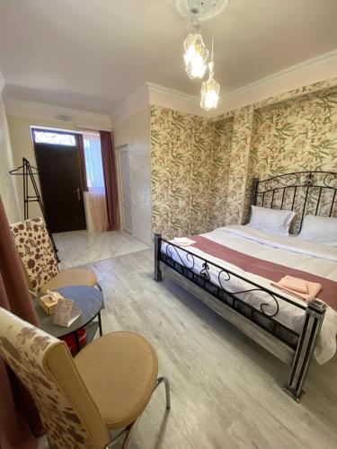 OdzunにあるYeghevni Guest House in Odzunのベッドとテーブルと椅子のある寝室