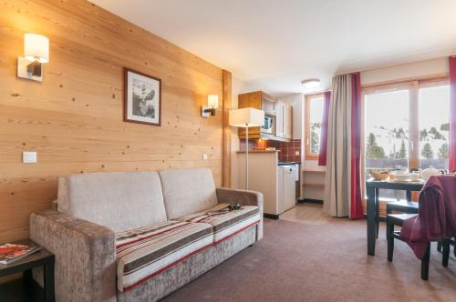 un salon avec un canapé et une table dans l'établissement Résidence Pierre & Vacances Le Quartz, à Belle Plagne