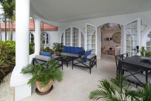 a patio with black tables and blue chairs at Fairmont Royal Pavilion Barbados Resort in Saint James