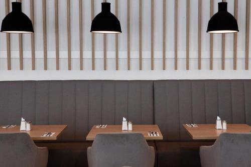 a dining room with tables and chairs and lights at Holiday Inn Berlin City East Side by IHG in Berlin
