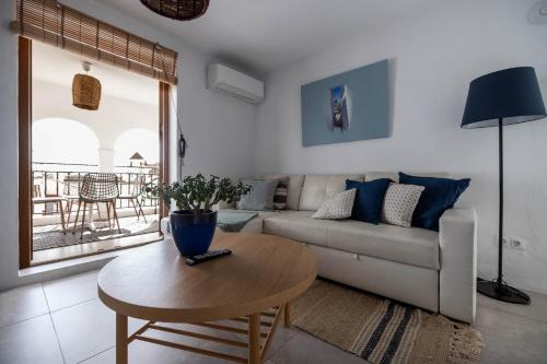 a living room with a couch and a table at Olive & Ivy Guesthouse in Canillas de Aceituno
