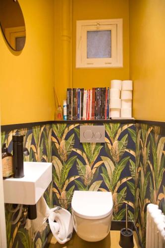 La salle de bains jaune est pourvue de toilettes et d'un lavabo. dans l'établissement Luxury Apt Paris 7 Invalides Tour Eiffel, à Paris