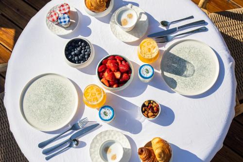 een witte tafel met borden en kommen met voedsel bij Lou Saint-Tropez in Saint-Tropez
