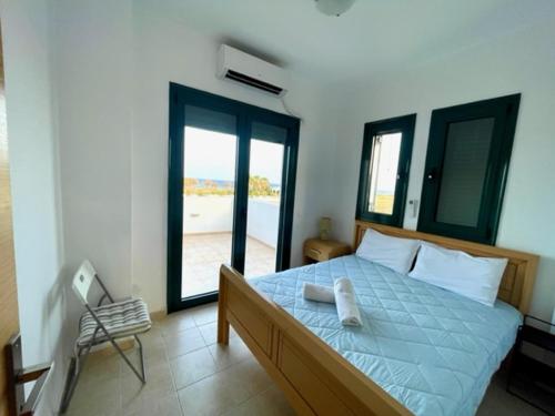 a bedroom with a bed with a blue comforter at Kelly's Beach House 1 in Gennadi
