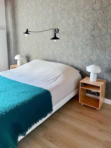 - une chambre avec un lit et une table avec deux lampes dans l'établissement T2 cosy proche golf et plage, à Capbreton