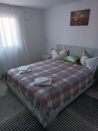 Un dormitorio con una cama con una manta a cuadros. en La Prietenicu, en Murighiol