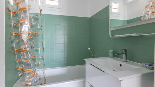 une salle de bain avec un rideau de douche avec des poissons rouges dans l'établissement SANTA MONICA II -112- Appt 4-6 pers avec veranda, au Cap d'Agde