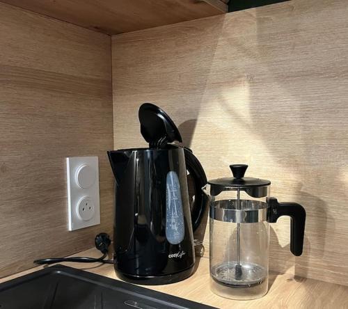 a black coffee pot sitting on top of a counter at La cabane tropicale in Pontorson