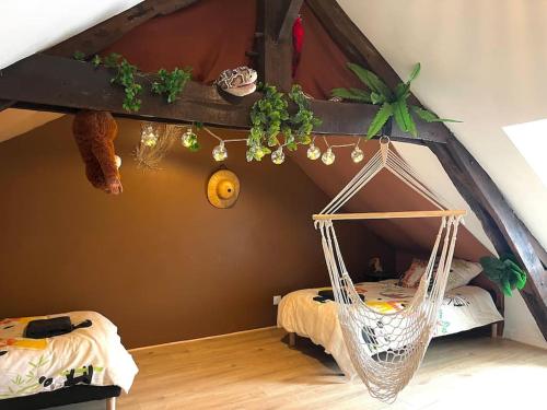 a room with a hammock in a bedroom at La cabane tropicale in Pontorson
