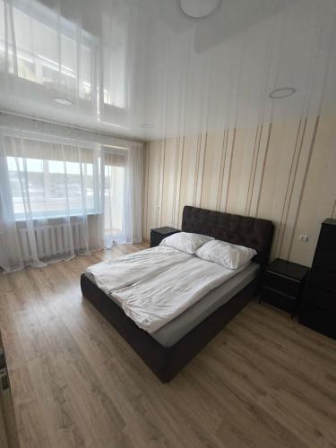 a bedroom with a bed and a large window at Sky View in Marijampolė