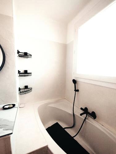 une salle de bain avec une baignoire et une fenêtre dans l'établissement Nid cosy, à Nice