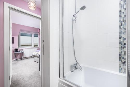a bathroom with a shower with a glass door at Heartseed House Bed & Breakfast in Dornoch
