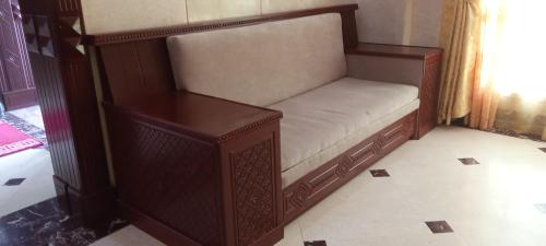 a wooden bench sitting in a room at Dahlia Sohar Hotel Apartments in Sohar
